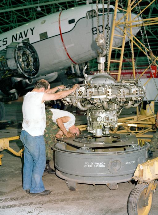 The engine of a C-117 aircraft is lowered into a shipping… — NARA and ...