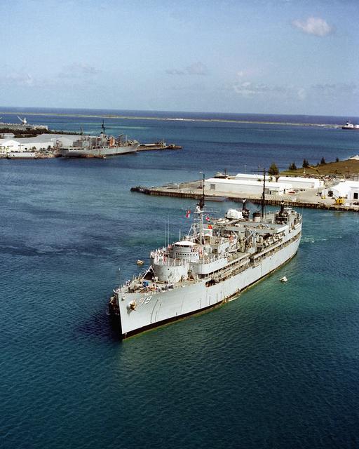 A harbor tugs positions the submarine tender USS PROTEUS… — NARA and ...