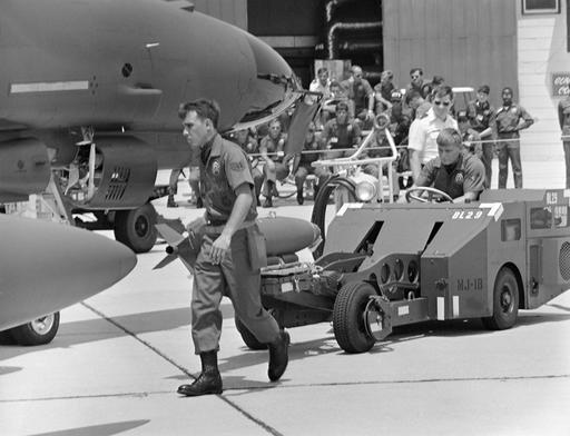 Munitions specialists use an MJ-1B bomb loader to load a… — NARA