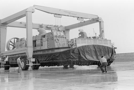 Members of Assault Craft Unit 4 (ACU 4) observe as a mobile lift raises ...