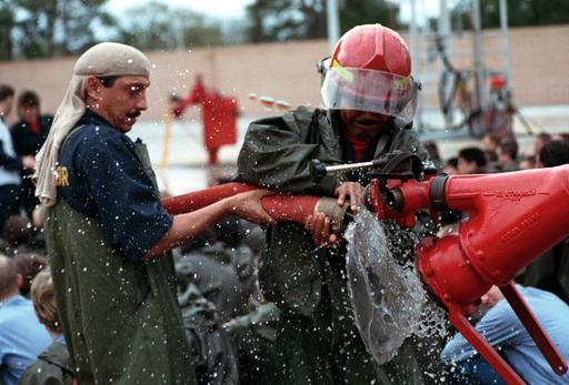 Two recruits practice connecting a fire hose to a hydrant during damage ...