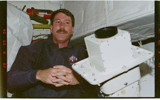 STS096-354-016 - STS-096 - CDR Rominger on middeck with EVA camera ...