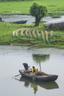 Two people in a small boat on a lake. Countryside wetlands natural.