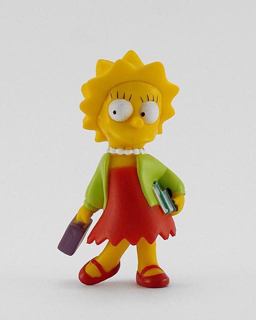 A figurine of a woman with a book in her hand. Toy… — PICRYL