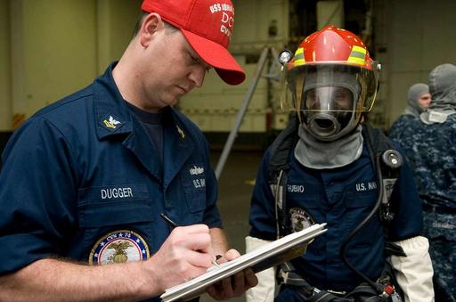 A training team member signs a roster for repair locker 1B during a ...