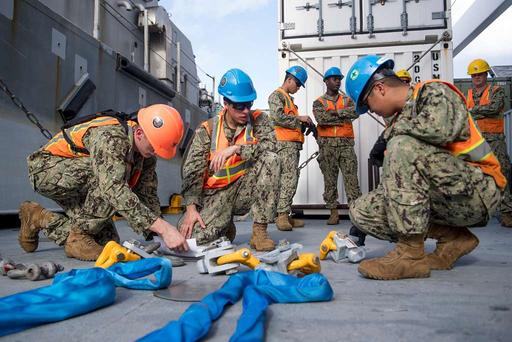 Sailors inspect rigging before conducting offload operations aboard the ...