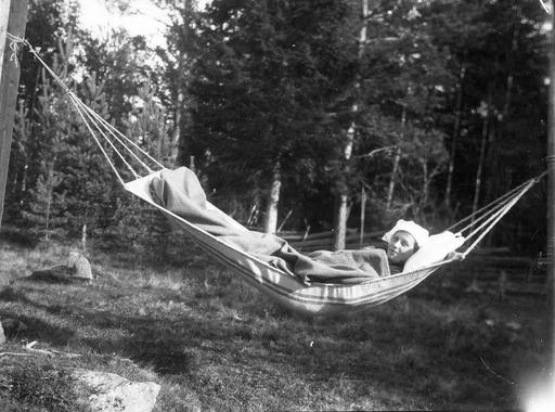 Flicka i hängmatta.Originaltext: Siesta i hängmattan vid Wittersjö (före giftermålet) Gunnar tog kortet., woman, hammock, siesta, wittersjo, rest, relaxation