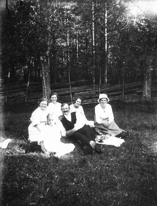 Originaltext: Från Wittersjö utanför stugan under granen. I bakre raden: Sofia, Cissi, fröken Malmgren, Etten. I främre raden: Ingrid, Gunnar., group portrait, cottage, fir tree, sofia, wittersjo, people, outdoor, historical