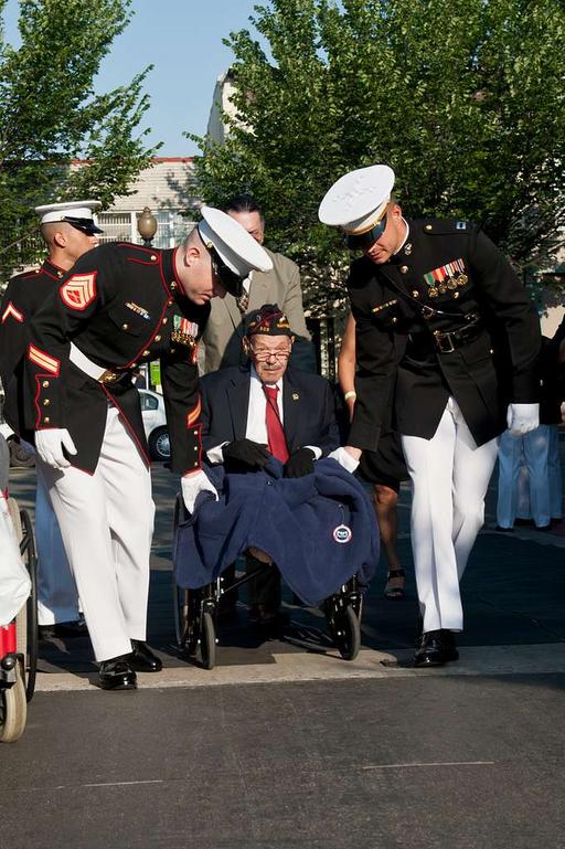 An original Montford Point Marine, center, is aided