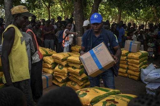 A World Food Programme worker distributes aid to local - NARA & DVIDS ...
