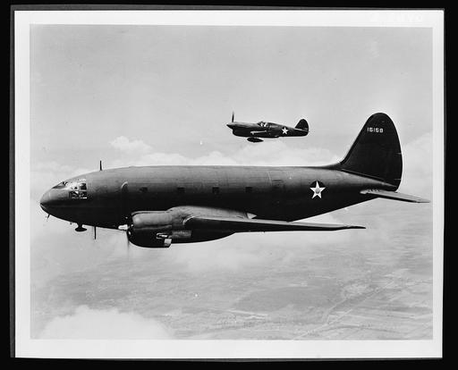 Самолеты в полете. Корабль на переднем плане - транспортный C-46, изначально спроектированный как коммерческий самолет для перевозки экипажа из пяти человек и тридцати шести пассажиров. Его грузоподъемность на военной службе значительно возросла. Более дальним самолетом является истребитель P-40, отличающийся своей эффективностью в работе на средних высотах с RAF (Королевскими ВВС) в Англии и Африке, с AB (Американскими Volunteer Group- Flying Tigers) в Китае и с AAF (Армейскими ВВС) в южной части Тихого океана., c 46 commando, transport aircraft, world war ii, military aviation, planes, flight, formation